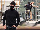 Tom Cruise grapples with a stuntman in a face mask as they practice for Mission Impossible filming