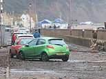 Sea defences are breached and cars are carried away on Dorset beach