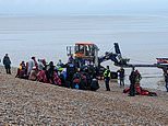 Mother clutches baby to chest as she scrambles up Kent beach after 200 migrants make Channel dash